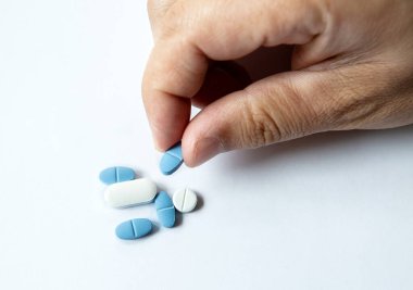 Erkeklerin elindeki farklı haplar yakın plan çekimleri ayırır.