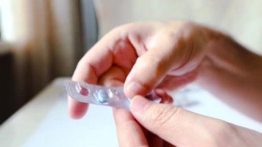 Bir sürü hapın paketlerini açıyorum. Beyaz arka plan. Ağız tableti paketleri açılıyor