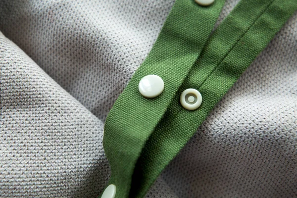 绿色网状辫子 扣子扣在浅灰织物的背景上 — 图库照片