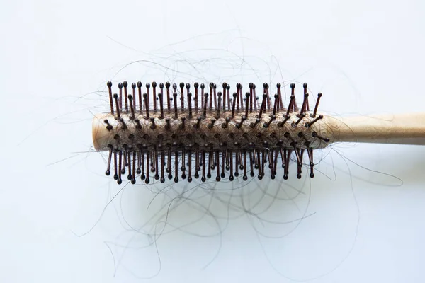 Beyaz arka planda çok saçı olan yuvarlak tarak, yakın plan saç kaybı, izole edilmiş.