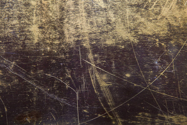 texture of the surface of the brass leaf, in scratches, background, close-up
