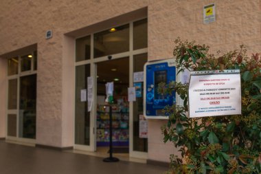 Florence, Toskana, İtalya - 03 / 20 / 2020: Coronavirus salgını, COVID-19 salgını, bir eczanenin önünde asılı uyarı işareti müşterileri kurallara uymaya davet ediyor