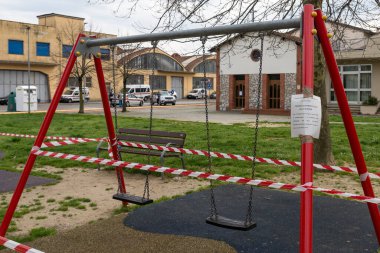 Toskana, İtalya - 03 / 20 / 2020: Coronavirüs salgını, COVID-19 salgını. Kapalı oyun alanları. Arka planda polis devriyesi sivilleri kontrol ediyor