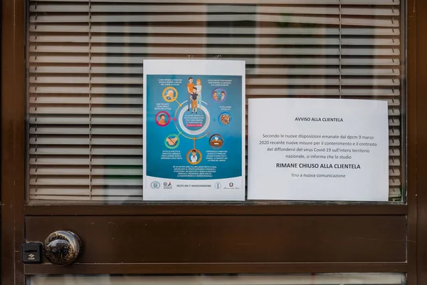 Toskana, İtalya - 03 / 20 / 2020: Coronavirüs salgını, COVID-19 salgını, tüm mağazaların ulusal kilit altına alınması. Dükkan camında kapanışı ve davranış kurallarını gösteren bir işaret var.