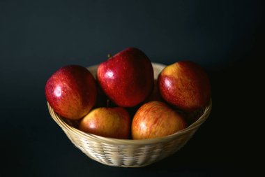 Siyah arka planda kırmızı elmalarla dolu bir sepet. Taze doğal tarım ürünleri. Sağlıklı yiyecekler, fitness. Organik yiyecekler