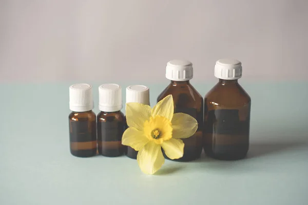 bottles of medicine lined up on a white background. beautiful yellow flower, spring. Chemical experiments, vaccines.