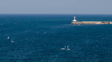 Yelkenli bir deniz feneri masmavi Denizi, Sevastopol, Crimea arka planı