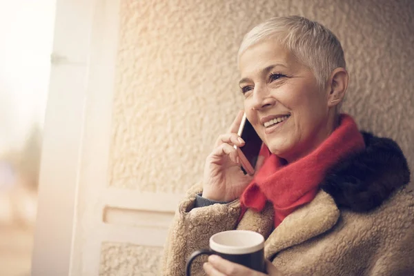 Gelukkig senior vrouw met een aangenaam telefoon gesprek — Stockfoto