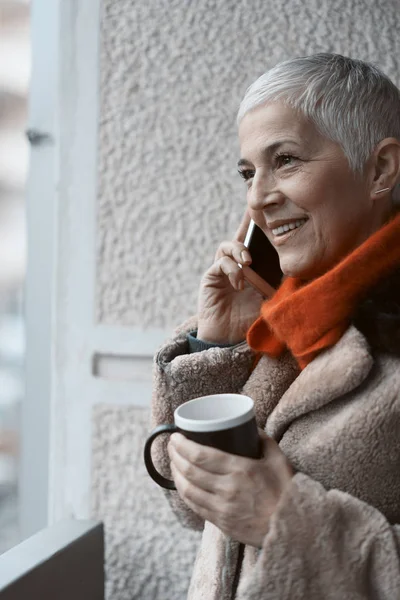 Gelukkig senior vrouw met een aangenaam telefoon gesprek — Stockfoto