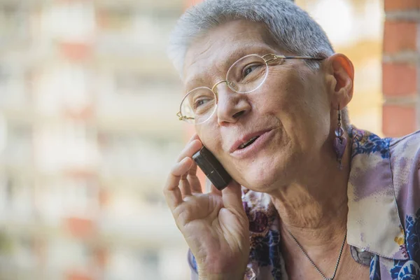 Senior vrouw na een vriendelijke gesprek over haar mobiele telefoon — Stockfoto