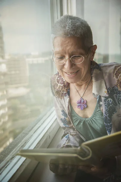 Abuela mirando algunas viejas fotografías en un álbum — Foto de Stock