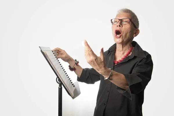 Senior signora praticare la sua abilità di canto, anziano voice coach si — Foto Stock