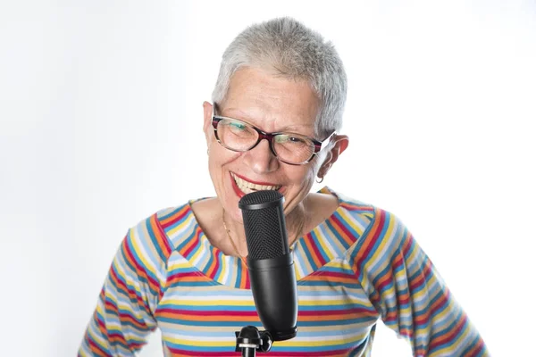 Kıdemli yaşlı kadının üzerinde profesyonel bir mikrofon şarkı — Stok fotoğraf