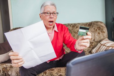Senior old woman shocked by her credit card bill clipart
