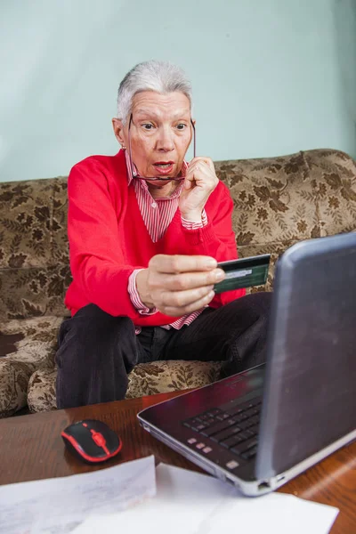 Senior oude vrouw geschokt door haar creditcard factuur — Stockfoto