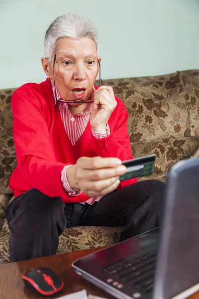 Senior oude vrouw geschokt door haar creditcard factuur — Stockfoto