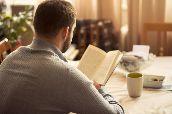 Homem lendo um livro em sua casa — Fotografia de Stock