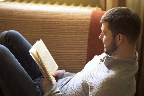 Jeune homme appréciant un grand livre — Photo