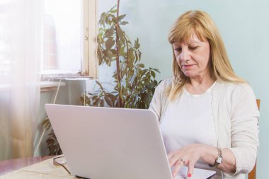 Yaşlı bayan internet'te gezinmek için onun kişisel bilgisayar kullanma