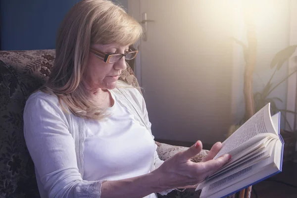 Femme blonde senior lisant un livre — Photo