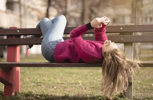 Freie fröhliche Frau, die ihr Handy an einem sonnigen Tag in einem Park benutzt — Stockfoto