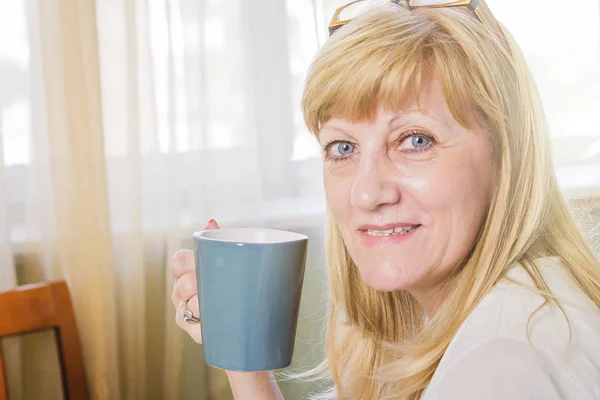 Happy senior lady with a cup of coffee — Stock Photo, Image