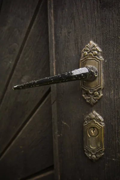 Old rustic door handle on wooden door