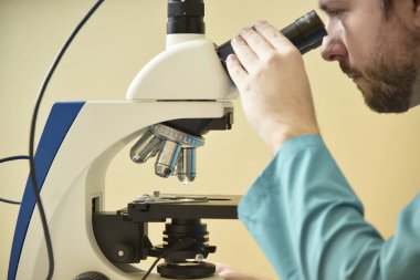 Genç doktor mikroskop üzerinde araştırma
