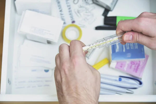 Checking body temperature with a thermometer — Stock Photo, Image