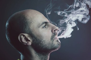 Bulut duman exhaling genç kel adam