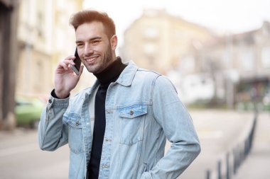 Bir gün sokakta zevk cep telefonu kullanan genç yakışıklı adam