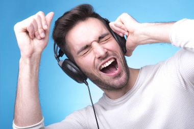 Yakışıklı adam bir cep telefonu üzerinde müzik keyfi