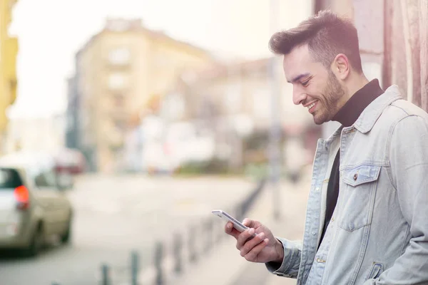 Bir gün sokakta zevk cep telefonu kullanan genç yakışıklı adam