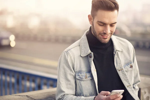 Young handsome man using his cell phone, enjoying a day on the street — Stock Photo, Image