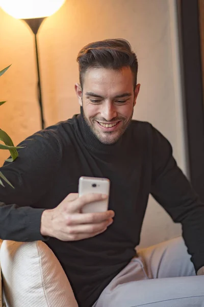 Man in een koffieshop gebruikt zijn mobiele telefoon — Stockfoto