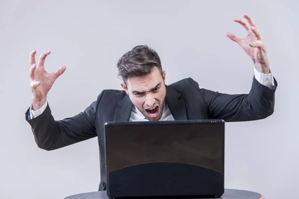 Giovane uomo d'affari arrabbiato con il suo computer portatile — Foto Stock