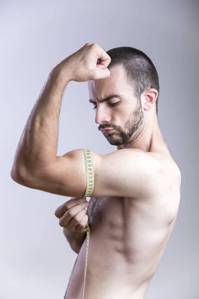 Man measuring his biceps size — Stock Photo, Image