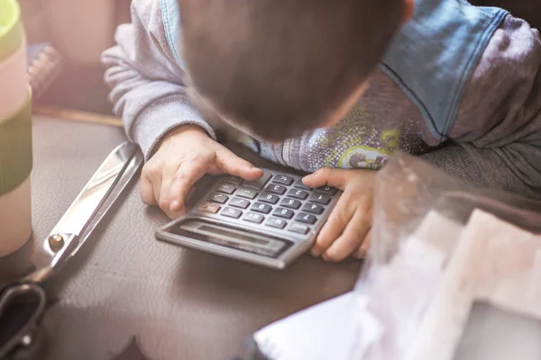 Lindo niñito usando una calculadora — Foto de Stock