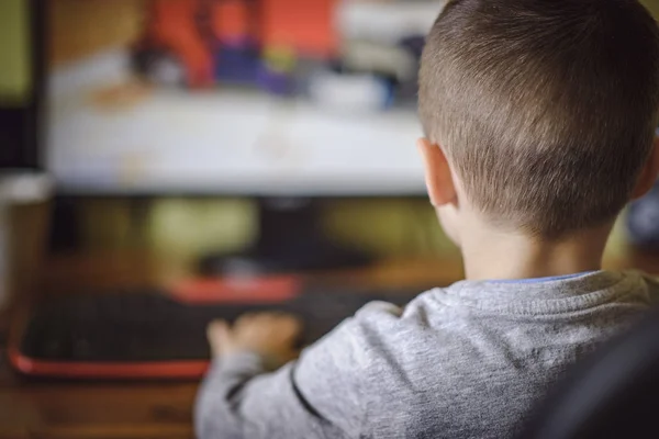 Jonge jongen spelen op een desktop computer Rechtenvrije Stockfoto's