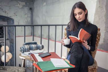 Genç kız öğrenci bir kafede bir kitap okuma