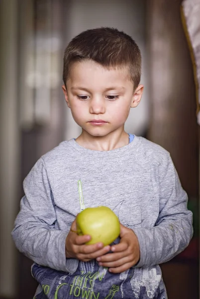 Cute little boy holding an apple — Stock Photo, Image