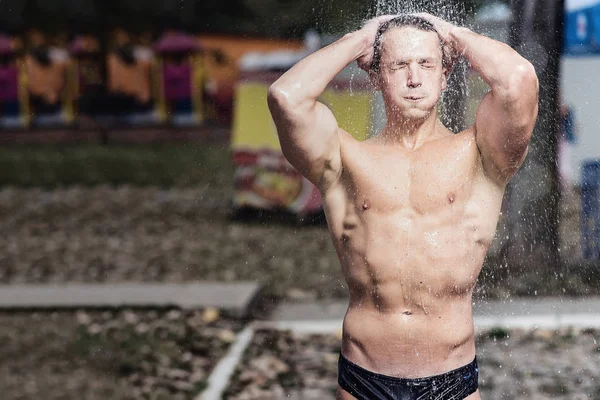 Sexy muscular man showering on the beach — Stock Photo, Image