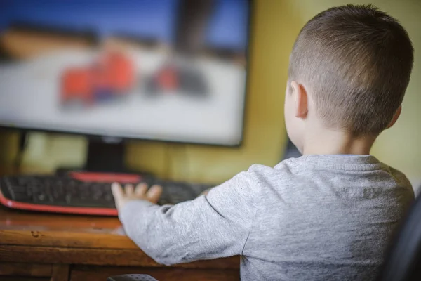 Jonge jongen spelen op een desktop computer Stockafbeelding