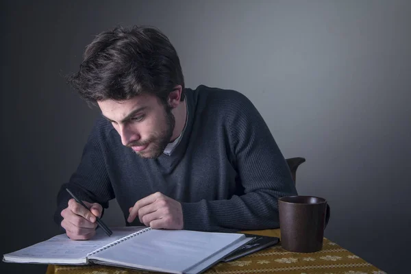 Jovem calculando, escrevendo e estudando — Fotografia de Stock