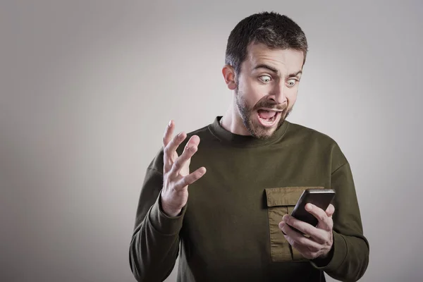 Homem com raiva de seu telefone, indignado e enfurecido — Fotografia de Stock