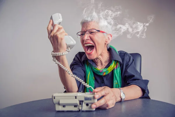 Schrecklicher Service, wütende Seniorin schreit am Telefon — Stockfoto