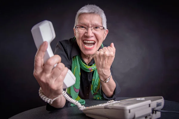 Ужасная служба, злая пожилая женщина, кричащая по телефону — стоковое фото