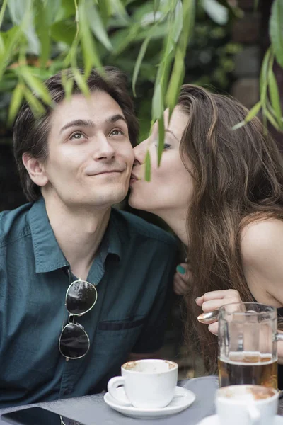 Молодая женщина целует мужчину на свидании — стоковое фото