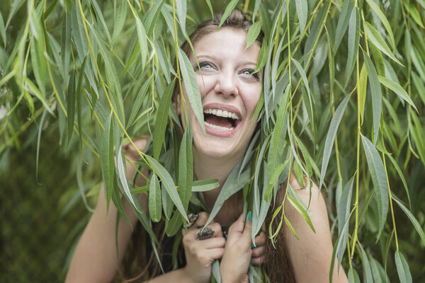 Happy cheerful woman covered with ivy leaves