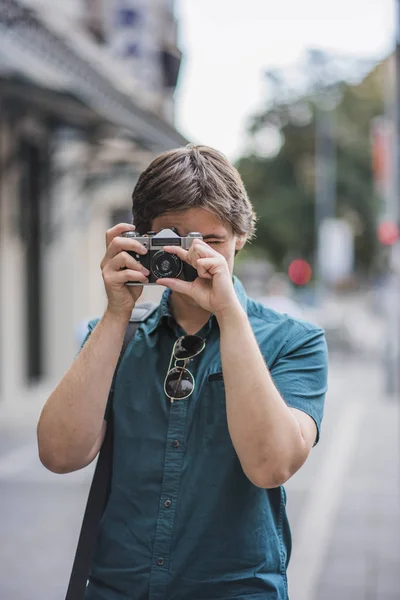 Joven fotógrafo tomando fotos callejeras — Foto de Stock